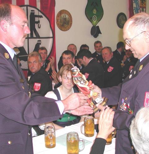 Georg König (links), Nachfolger von Oswald Bartl (rechts) als Kreisbrandinspektor überreicht zum Abschied aus dem aktiven Dienst eine Floriani-Figur.